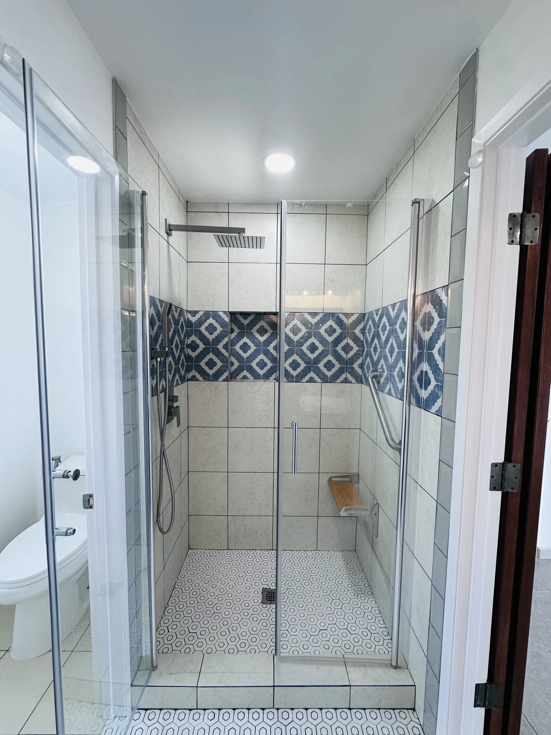 Walk-in shower remodel with patterned blue tile accent