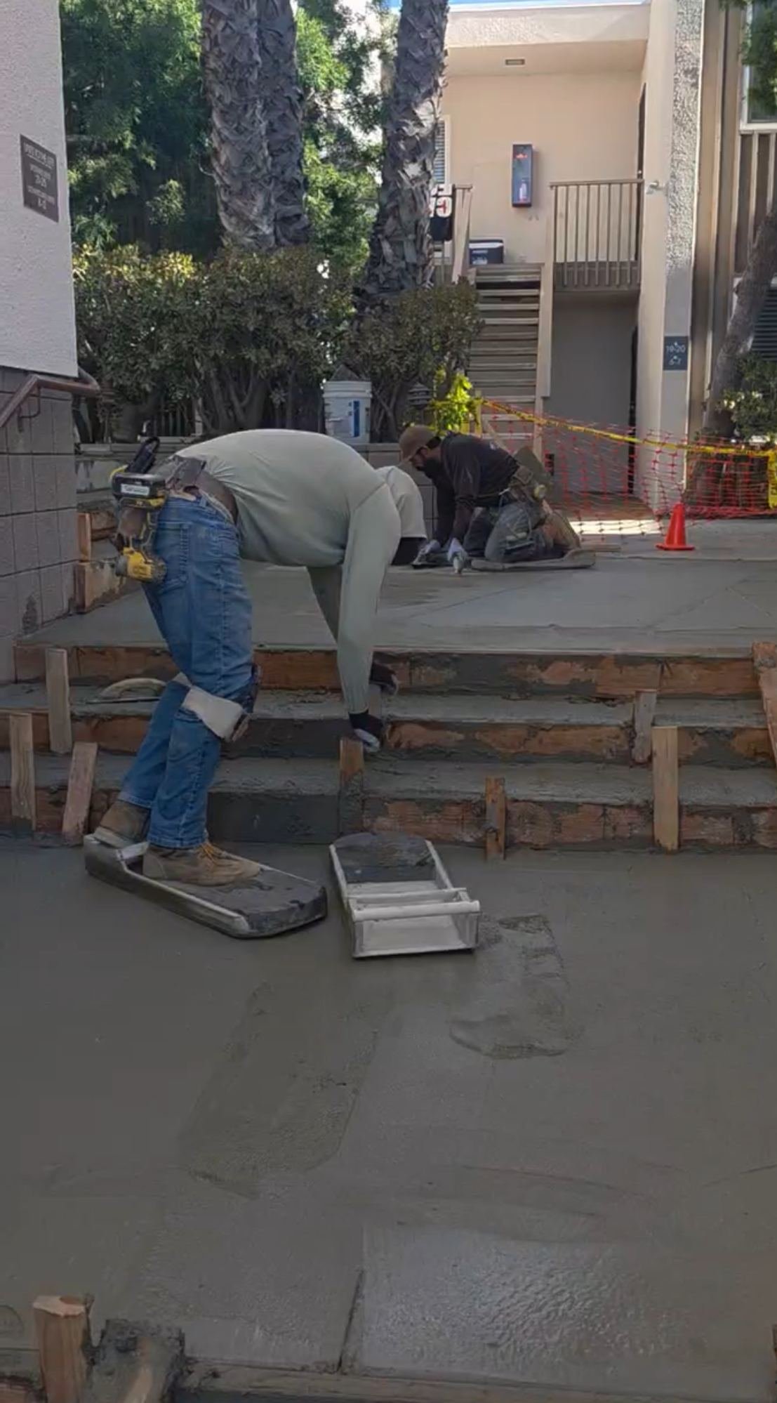 Cordada Construction crew floating and finishing freshly poured concrete flatwork and steps