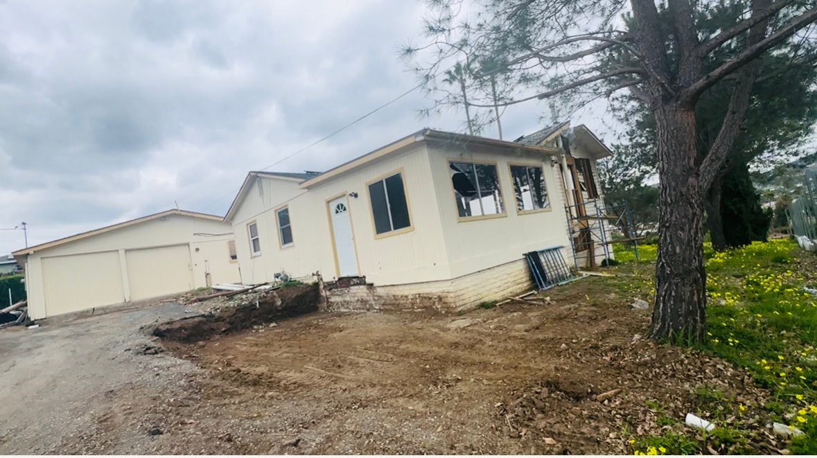 Existing home and garage before ADU construction began, with site grading underway in Vista, California